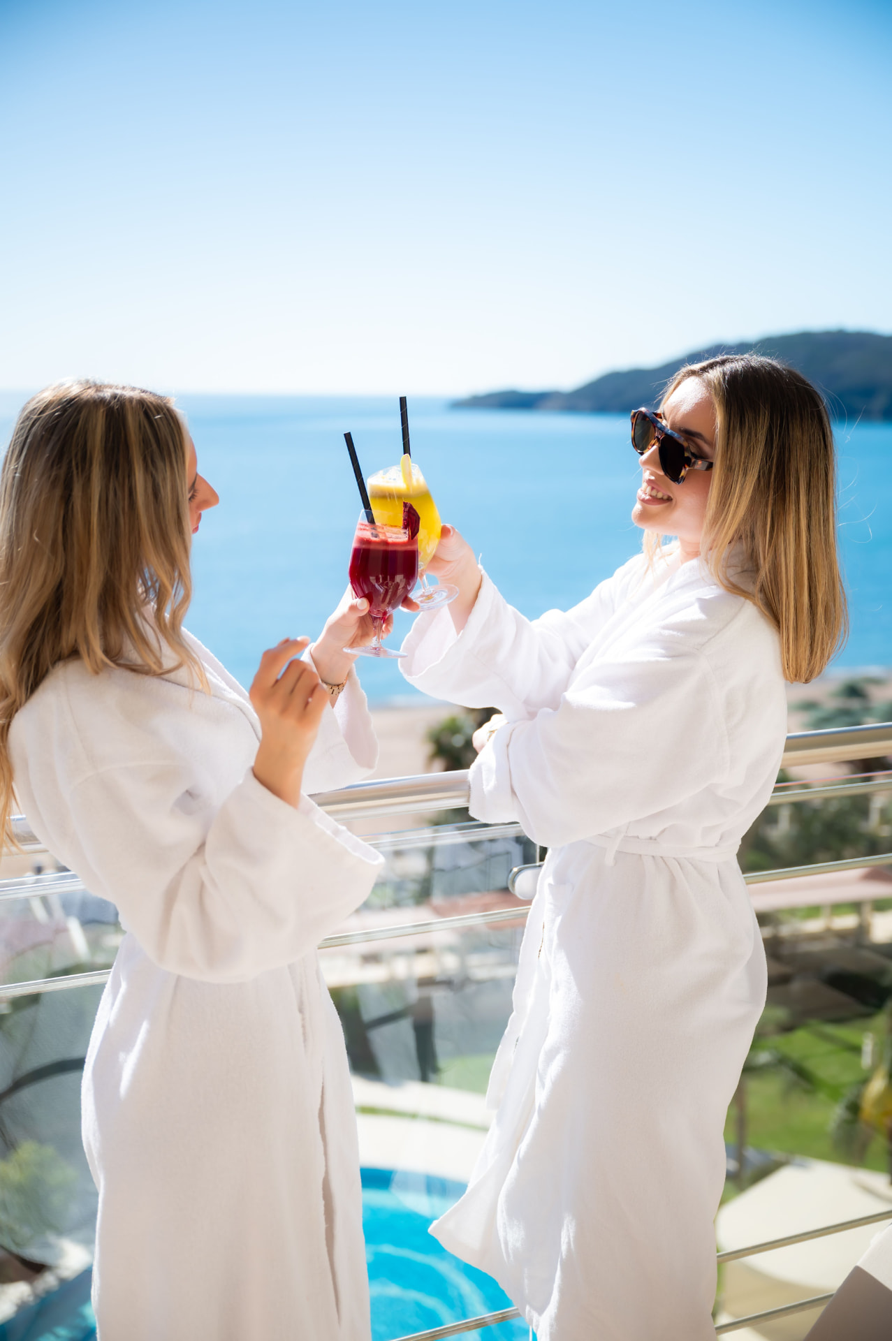 Friends celebrating a relaxing resort stay overlooking the coast